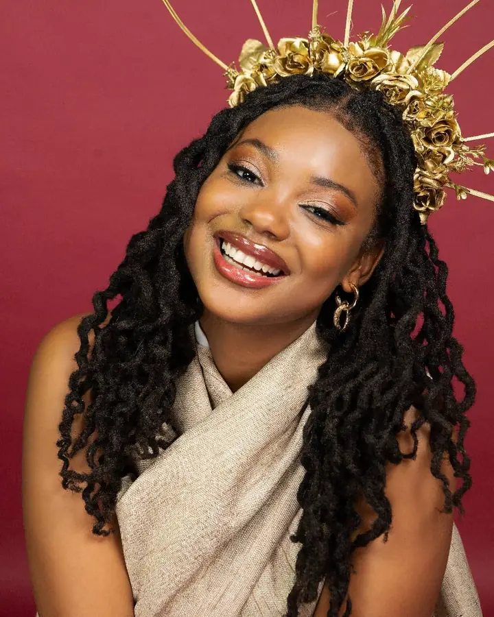 Smiling in a gold rose crown and a wrapped neutral top